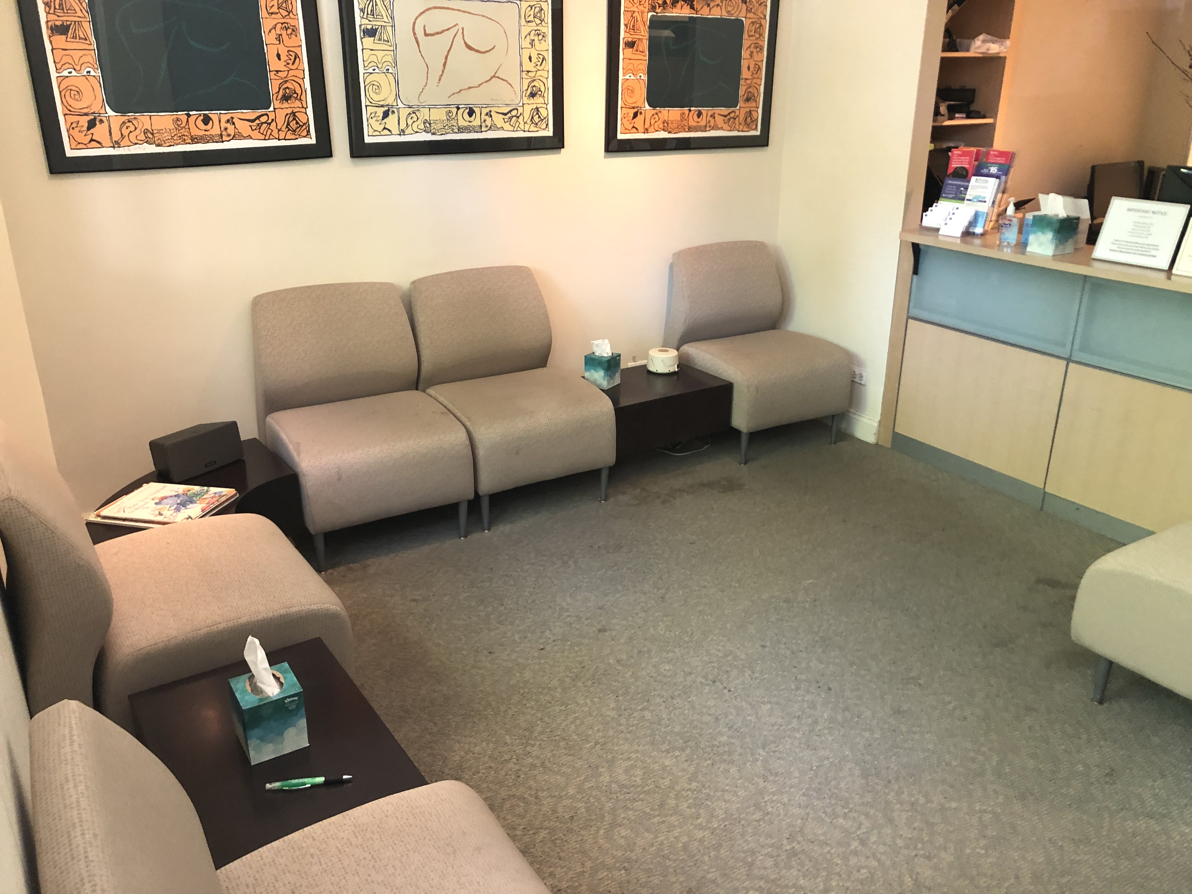 Waiting room with couch, chairs, and a book